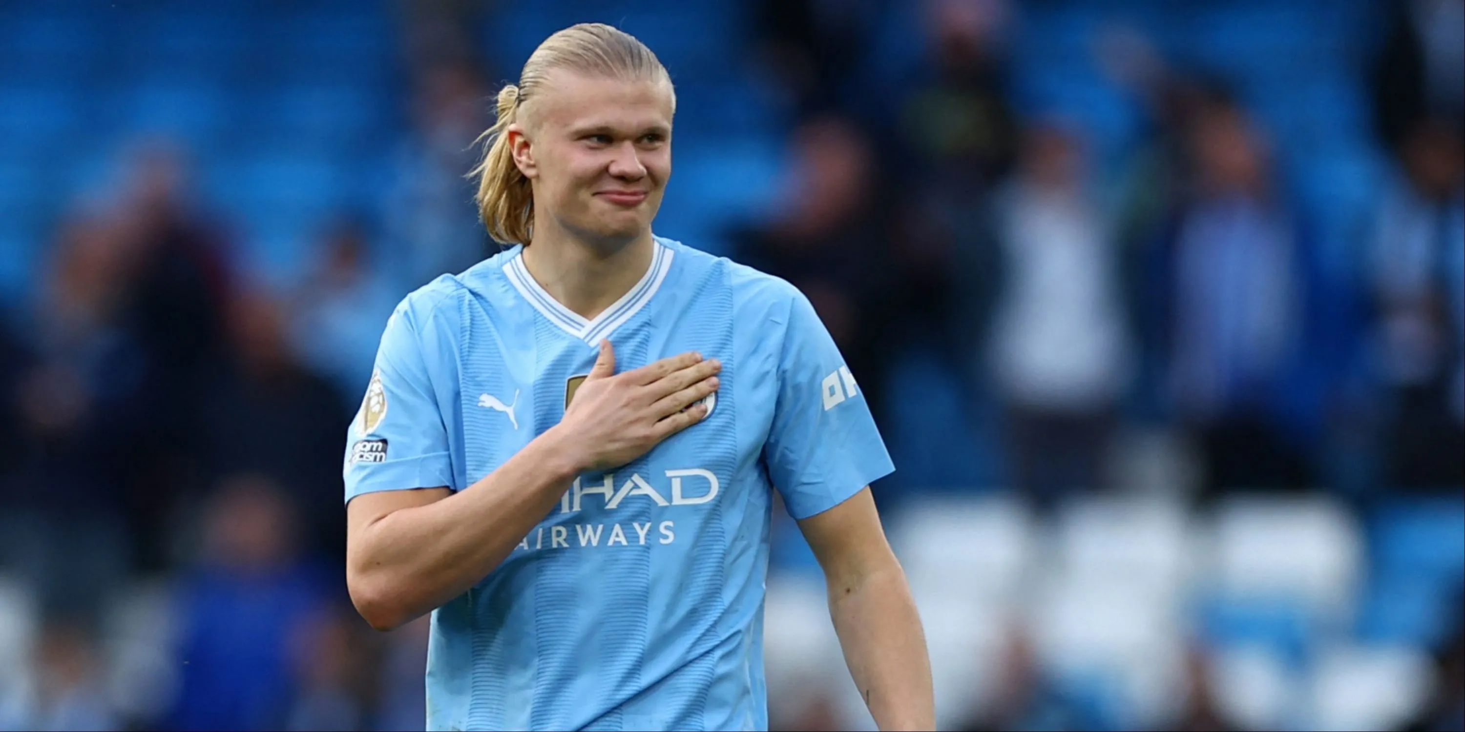 Tiền đạo Erling Haaland vỗ vào logo Manchester City, biểu tượng sức mạnh của anh.